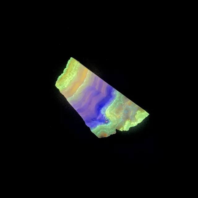 Hokkaidoite slice 1C01 under UV light (3/11) — 4.4 × 2.3 × 0.9 cm, Hokkaido, Japan · Kitsune Mineral