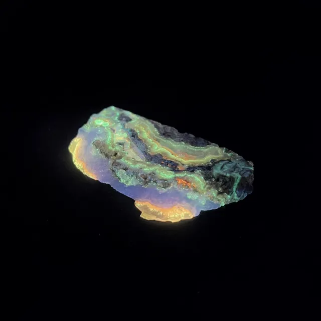 Hokkaidoite slice 2B14 under UV light (3/11) — 6.6 × 3.8 × 0.6 cm, Hokkaido, Japan · Kitsune Mineral