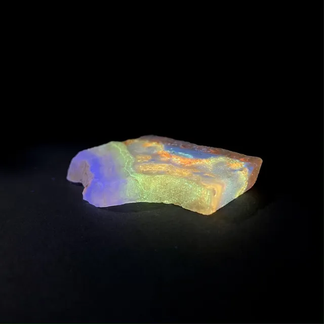 Hokkaidoite slice AL04 under UV light (3/9) — 6.4 × 4.2 × 0.8 cm, Hokkaido, Japan · Kitsune Mineral