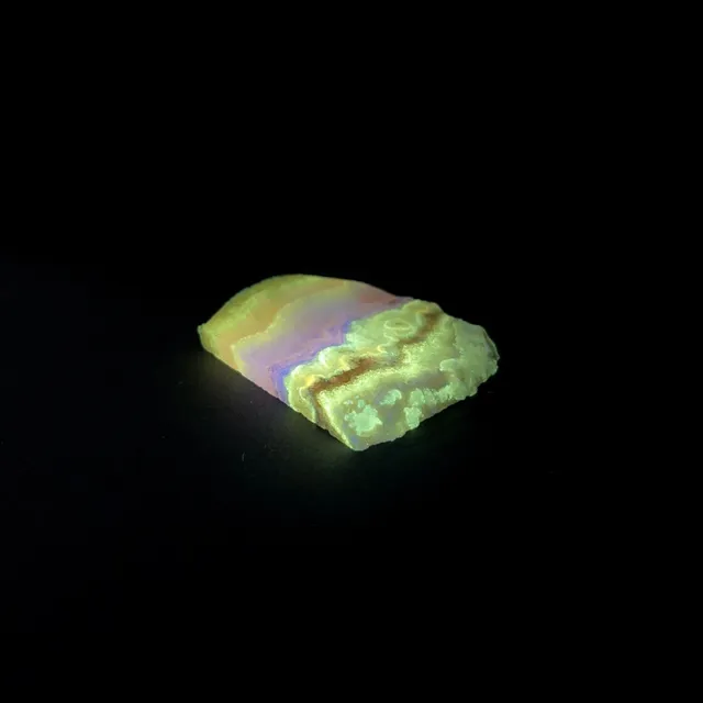 Hokkaidoite slice AM02 under UV light (3/8) — 4.8 × 4.0 × 0.5 cm, Hokkaido, Japan · Kitsune Mineral