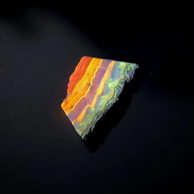 Hokkaidoite slice BL02 under UV light (3/12) — 7.9 × 4.4 × 0.7 cm, Hokkaido, Japan · Kitsune Mineral
