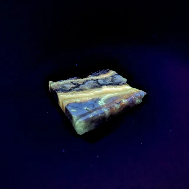 Hokkaidoite slice CS01 under UV light (3/9) — 3.3 × 2.8 × 0.4 cm, Hokkaido, Japan · Kitsune Mineral